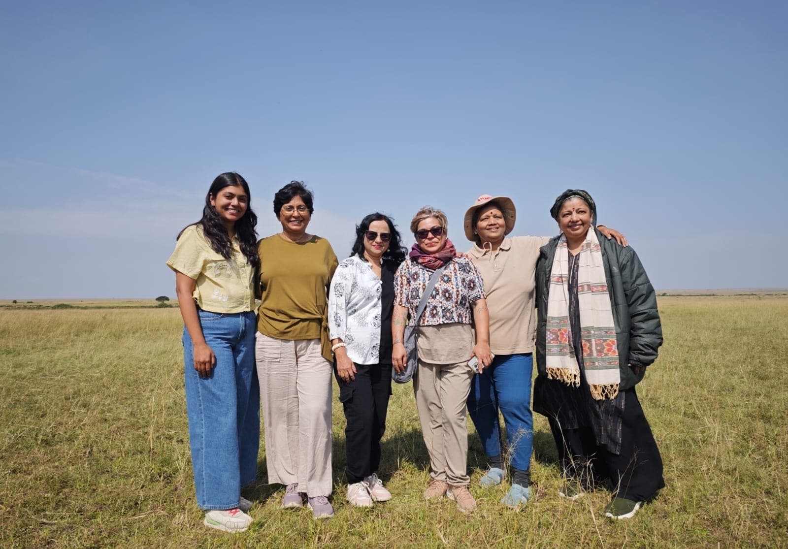 Photographers on safari in the Masai Mara with telephoto lenses at golden hour. © Nitin Vyas