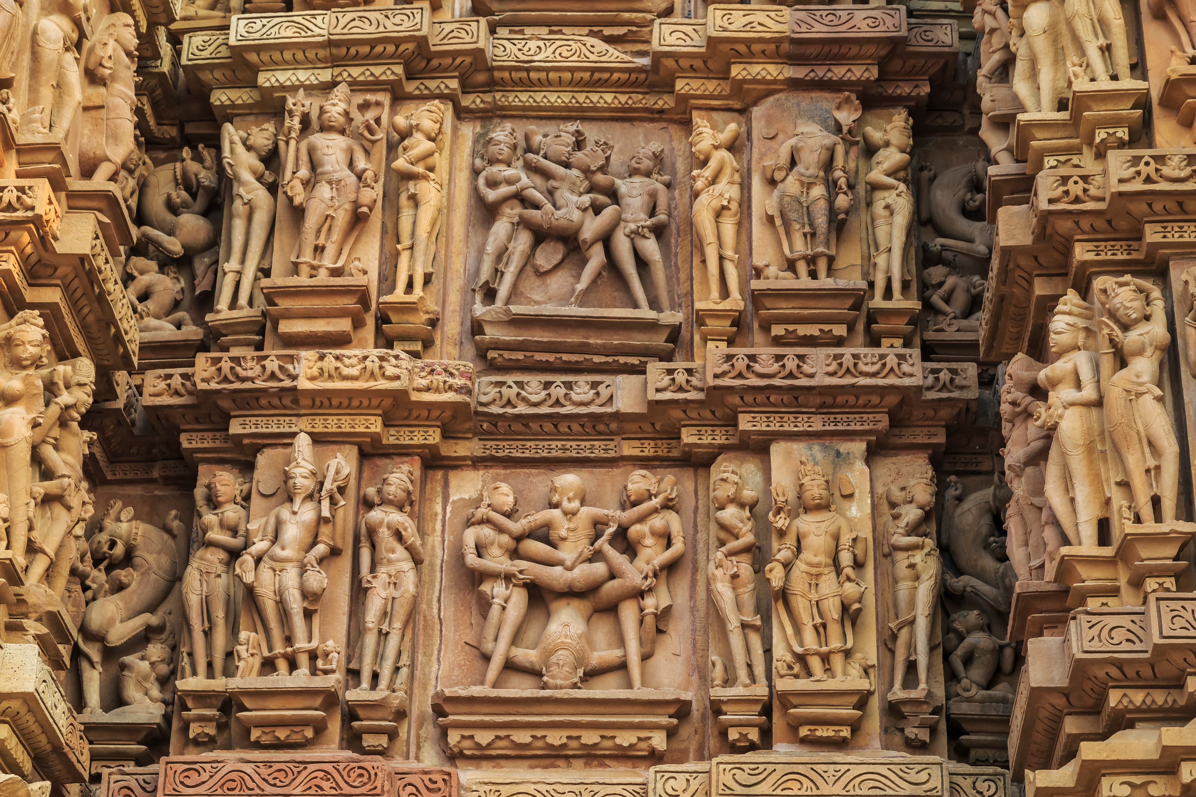 Intricate erotic stone carvings on the exterior wall of a Khajuraho temple